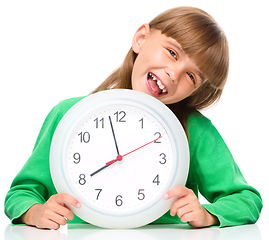 Image showing Little girl is holding big clock