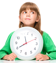 Image showing Little girl is holding big clock