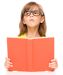 Image showing Little girl is reading a book