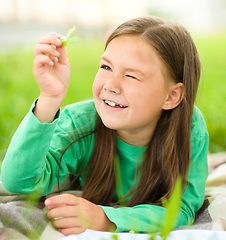 Image showing Portrait of a little girl laying on green grass