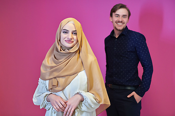 Image showing Portrait of happy young muslim couple standing isolated on pink background