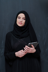 Image showing Young Arab businesswoman in traditional clothes or abaya with tablet computer