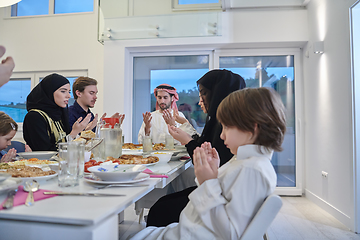 Image showing Muslim family making iftar dua to break fasting during Ramadan.