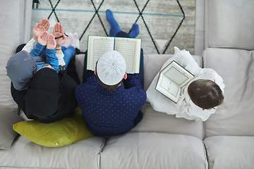 Image showing Top view of young muslim family reading Quran during Ramadan