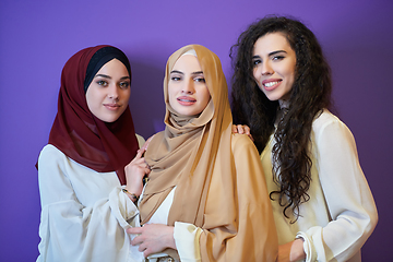 Image showing Young muslim women posing on purple background