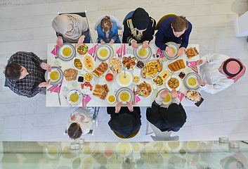 Image showing Top view of Muslim family making iftar dua to break fasting during Ramadan.