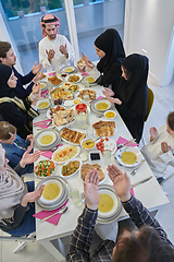 Image showing Muslim family making iftar dua to break fasting during Ramadan.