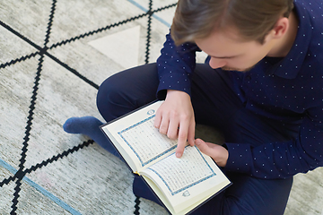 Image showing Young muslim man reading Quran during Ramadan