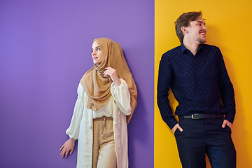 Image showing Portrait of happy young muslim couple standing isolated on colorful background