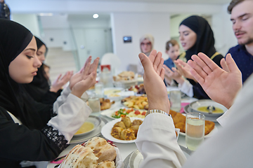 Image showing Muslim family making iftar dua to break fasting during Ramadan.