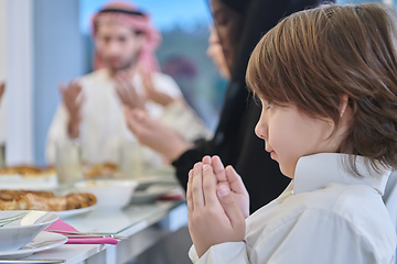 Image showing Muslim family making iftar dua to break fasting during Ramadan.