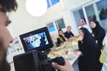 Image showing Professional videograph recording video while Muslim family having iftar together during Ramadan