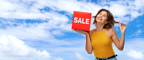 Image showing happy smiling young woman posing with sale sign