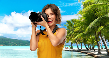 Image showing happy woman photographer with camera on beach