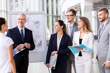 Image showing business team with scheme on flip chart at office