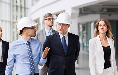 Image showing business team in helmets walking along office