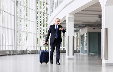 Image showing senior businessman walking with travel bag