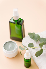 Image showing serum, clay mask, oil and eucalyptus on bath towel