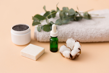 Image showing serum, clay mask, oil and eucalyptus on bath towel