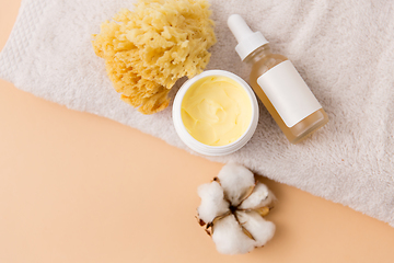 Image showing body butter, essential oil, sponge on bath towel