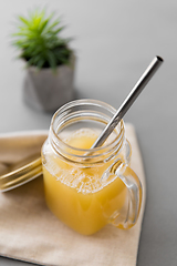 Image showing glass mug of juice and reusable metallic straw