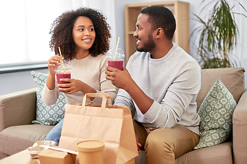 Image showing happy couple with takeaway food and drinks at home