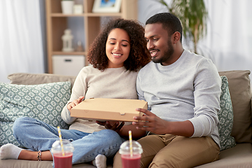 Image showing happy african american couple eating pizza at home