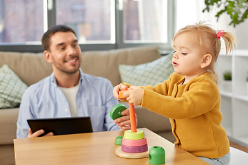 Image showing father with tablet pc and baby daughter at home