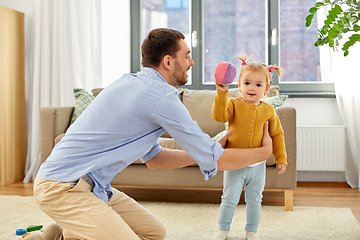 Image showing father and baby daughter playing with ball at home