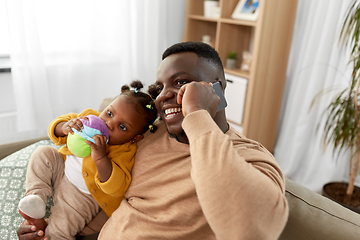 Image showing father with baby at home calling on smartphone