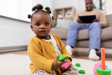 Image showing african baby girl playing with toy blocks at home