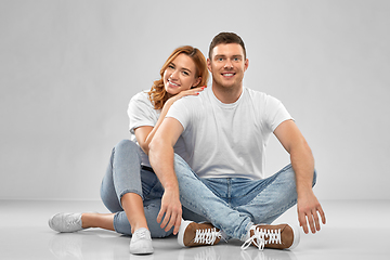 Image showing happy couple in white t-shirts sitting on floor