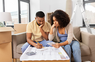 Image showing sad couple with blueprint counting money at home