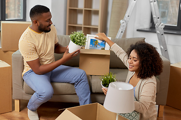 Image showing happy couple packing boxes and moving to new home