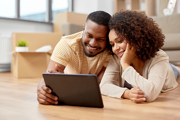 Image showing happy couple with tablet pc computer at new home