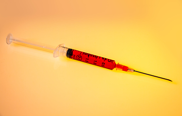 Image showing Syringe with blood on orange background