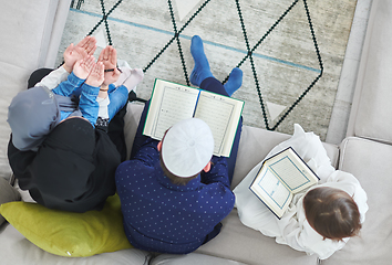 Image showing Top view of young muslim family reading Quran during Ramadan