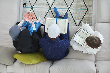 Image showing Top view of young muslim family reading Quran during Ramadan