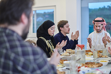 Image showing Muslim family making iftar dua to break fasting during Ramadan.