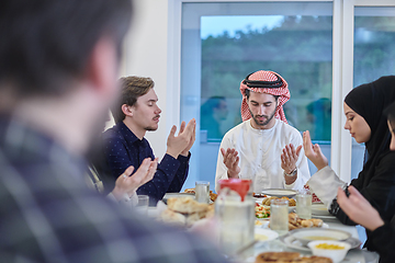 Image showing Muslim family making iftar dua to break fasting during Ramadan.