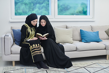 Image showing Portrait of young muslim women reading Quran in modern home.