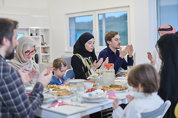 Image showing Muslim family making iftar dua to break fasting during Ramadan.