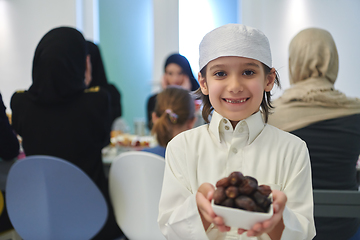 Image showing Arabian kid in the traditional clothes during iftar