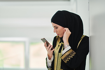 Image showing Portrait of Arab woman in traditional clothes using mobile phone