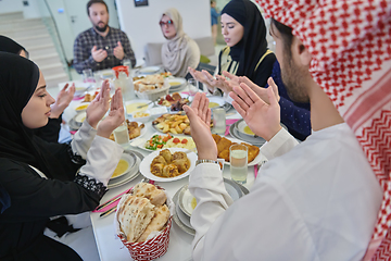 Image showing Muslim family making iftar dua to break fasting during Ramadan.