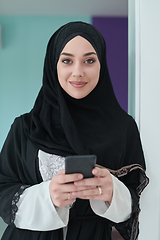 Image showing Portrait of Arab woman in traditional clothes using mobile phone.