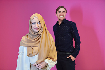 Image showing Portrait of happy young muslim couple standing isolated on pink background