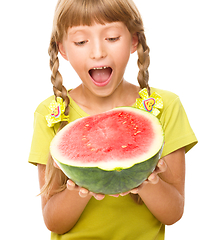 Image showing Little girl is eating watermelon