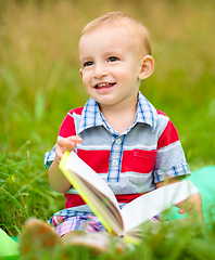 Image showing Little boy is reading book