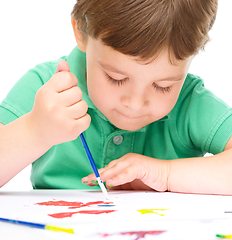 Image showing Little boy is playing with paints